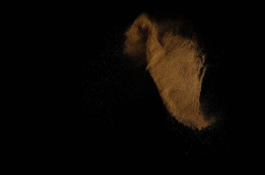 Toprak patlaması siyah arka planda izole edildi. Kahverengi zemin soyut bulutu.