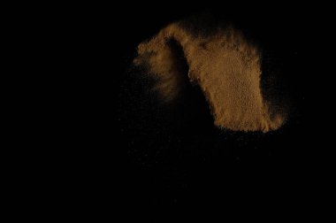 Toprak patlaması siyah arka planda izole edildi. Kahverengi zemin soyut bulutu.