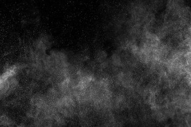 Siyah zemin üzerindeki beyaz parçacıkların hareketlerini dondur. Barut patlaması. Soyut toz tabakası dokusu.