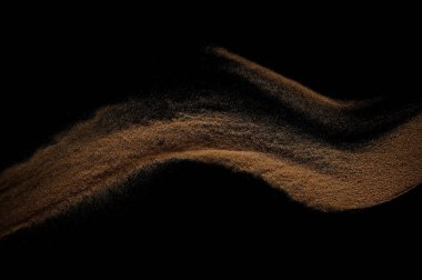 Kum dalgası siyah arkaplanda izole edildi. Soyut kum tepeciği.