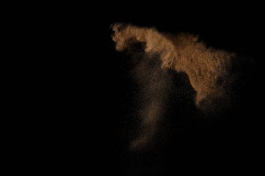 Kumsal patlaması siyah arka planda izole edildi. Soyut kum bulutu.