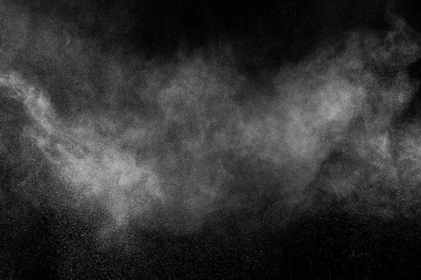 Freeze motion of white particles on black background. Powder explosion. Abstract dust overlay texture.