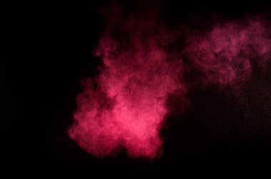 Siyah zemin üzerine kırmızı ve pembe toz patlama. Renkli toz bulutu. Renkli toz patlayabilir. Boya Holi.