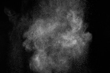 Siyah zemin üzerindeki beyaz parçacıkların hareketlerini dondur. Barut patlaması. Soyut toz tabakası dokusu.