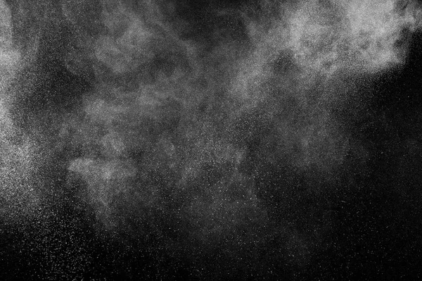 Freeze motion of white particles on black background. Powder explosion. Abstract dust overlay texture.