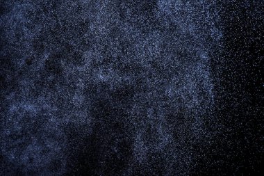 Siyah arka plan üzerine su sıçramalarına soyut mavi. Beyaz parçacıkların hareket dondurmak. Yağmur, kar doku yerleşimi..