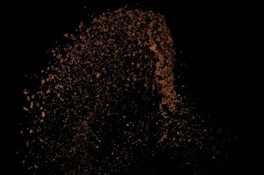 Toprak patlaması siyah arka planda izole edildi. Kahverengi zemin soyut bulutu.