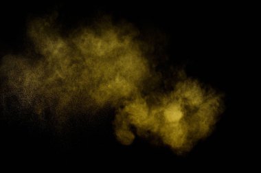 Siyah zemin üzerine sarı tozu patlama. Renkli toz bulutu. Renkli toz patlayabilir. Boya Holi.