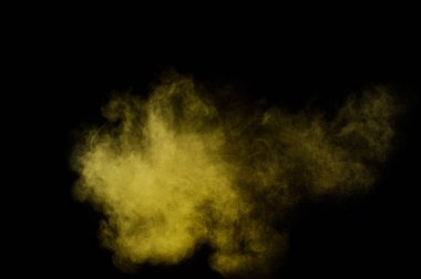 Siyah zemin üzerine sarı tozu patlama. Renkli toz bulutu. Renkli toz patlayabilir. Boya Holi.