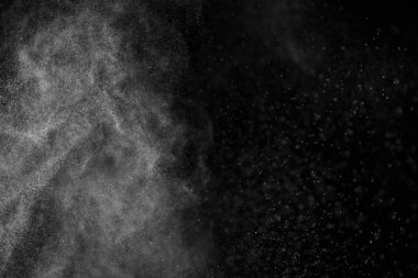 Siyah arka planda soyut su sıçramaları. Beyaz parçacıkların hareketlerini dondur. Yağmur, kar örtüsü dokusu.