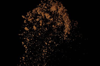 Toprak patlaması siyah arka planda izole edildi. Kahverengi zemin soyut bulutu.