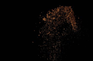 Toprak patlaması siyah arka planda izole edildi. Kahverengi zemin soyut bulutu.