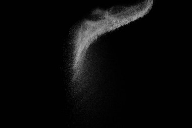 Siyah zemin üzerindeki beyaz parçacıkların hareketlerini dondur. Barut patlaması. Soyut toz tabakası dokusu.