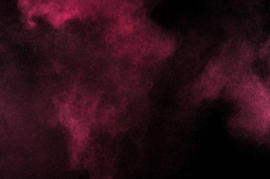 Siyah zemin üzerine kırmızı toz patlama. Pembe bulut. Kırmızı toz patlayabilir. Hareket boya Holi dondur.