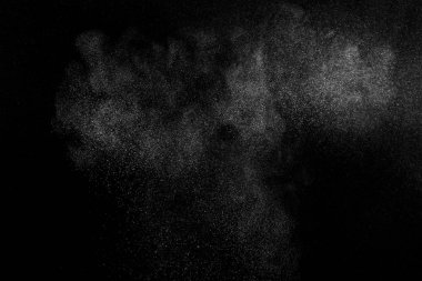 Siyah zemin üzerindeki beyaz parçacıkların hareketlerini dondur. Barut patlaması. Soyut toz tabakası dokusu.