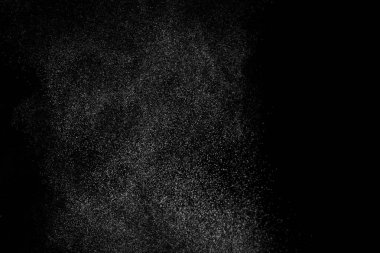 Siyah arka planda soyut su sıçramaları. Beyaz parçacıkların hareketlerini dondur. Yağmur, kar örtüsü dokusu.