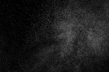 Siyah arka planda soyut su sıçramaları. Beyaz parçacıkların hareketlerini dondur. Yağmur, kar örtüsü dokusu.