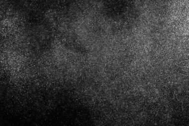 Siyah zemin üzerindeki beyaz parçacıkların hareketlerini dondur. Barut patlaması. Soyut toz tabakası dokusu.