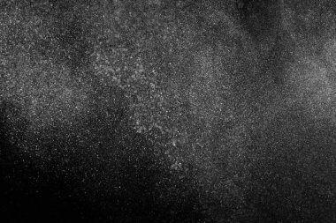 Siyah zemin üzerindeki beyaz parçacıkların hareketlerini dondur. Barut patlaması. Soyut toz tabakası dokusu.