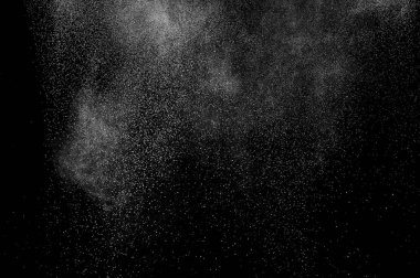 Siyah zemin üzerindeki beyaz parçacıkların hareketlerini dondur. Barut patlaması. Soyut toz tabakası dokusu.