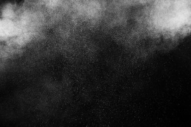 Siyah zemin üzerindeki beyaz parçacıkların hareketlerini dondur. Barut patlaması. Soyut toz tabakası dokusu.