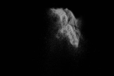 Siyah zemin üzerindeki beyaz parçacıkların hareketlerini dondur. Barut patlaması. Soyut toz tabakası dokusu.