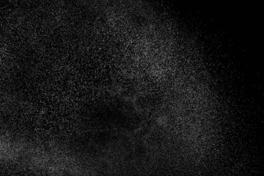 Siyah arka planda soyut su sıçramaları. Beyaz parçacıkların hareketlerini dondur. Yağmur, kar örtüsü dokusu.