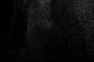 Siyah zemin üzerindeki beyaz parçacıkların hareketlerini dondur. Barut patlaması. Soyut toz tabakası dokusu.