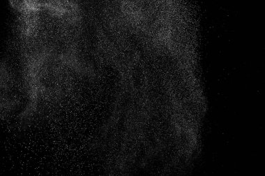 Siyah zemin üzerindeki beyaz parçacıkların hareketlerini dondur. Barut patlaması. Soyut toz tabakası dokusu.