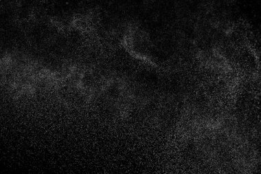 Siyah arka planda soyut su sıçramaları. Beyaz parçacıkların hareketlerini dondur. Yağmur, kar örtüsü dokusu.