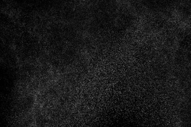 Siyah arka planda soyut su sıçramaları. Beyaz parçacıkların hareketlerini dondur. Yağmur, kar örtüsü dokusu.