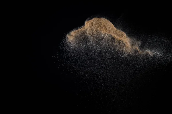 Sandy explosion isolated on black background. Abstract particles cloud. Texture element for design.