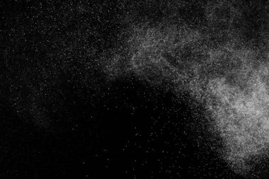 Siyah arka planda soyut su sıçramaları. Beyaz parçacıkların hareketlerini dondur. Yağmur, kar örtüsü dokusu.