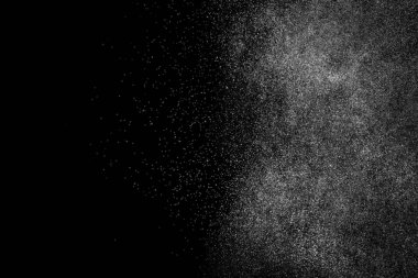 Siyah arka planda soyut su sıçramaları. Beyaz parçacıkların hareketlerini dondur. Yağmur, kar örtüsü dokusu.