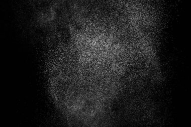 Siyah arka planda soyut su sıçramaları. Beyaz parçacıkların hareketlerini dondur. Yağmur, kar örtüsü dokusu.