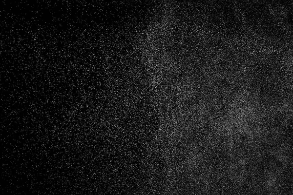 Siyah arka planda soyut su sıçramaları. Beyaz parçacıkların hareketlerini dondur. Yağmur, kar örtüsü dokusu.