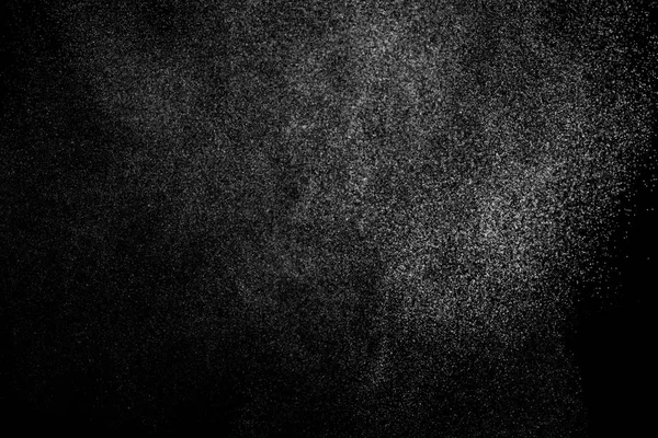 Siyah arka planda soyut su sıçramaları. Beyaz parçacıkların hareketlerini dondur. Yağmur, kar örtüsü dokusu.