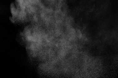 Siyah arka plan üzerine beyaz toz patlama. Soyut toz doku.