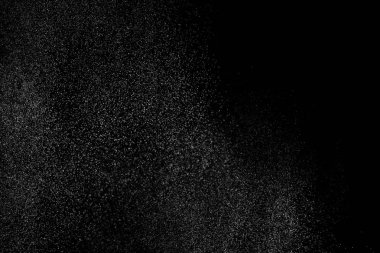 Siyah arka planda soyut su sıçramaları. Beyaz parçacıkların hareketlerini dondur. Yağmur, kar örtüsü dokusu.