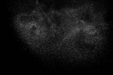 Siyah arka planda soyut su sıçramaları. Beyaz parçacıkların hareketlerini dondur. Yağmur, kar örtüsü dokusu.