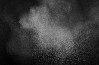 Siyah arka plan üzerine beyaz toz patlama. Soyut toz doku.