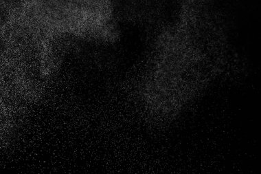 Siyah arka planda soyut su sıçramaları. Beyaz parçacıkların hareketlerini dondur. Yağmur, kar örtüsü dokusu.