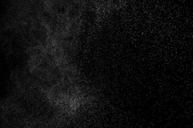 Siyah arka planda soyut su sıçramaları. Beyaz parçacıkların hareketlerini dondur. Yağmur, kar örtüsü dokusu.