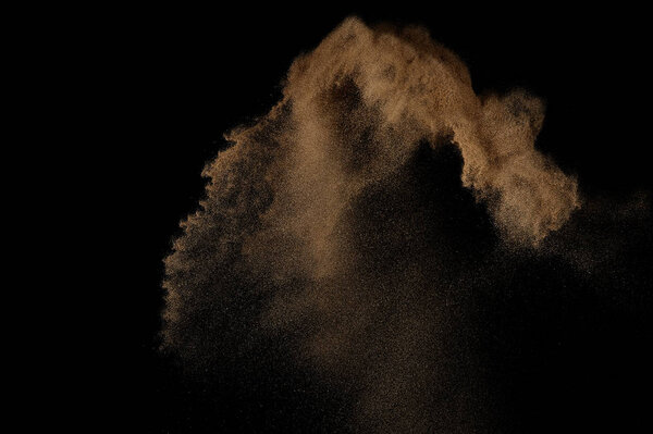 Sandy explosion isolated on black background. Abstract sand cloud.