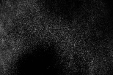 Siyah arka planda soyut su sıçramaları. Beyaz parçacıkların hareketlerini dondur. Yağmur, kar örtüsü dokusu.