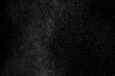 Siyah arka planda soyut su sıçramaları. Beyaz parçacıkların hareketlerini dondur. Yağmur, kar örtüsü dokusu.