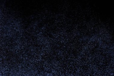 Siyah arka plan üzerine su sıçramalarına soyut mavi. Beyaz parçacıkların hareket dondurmak. Yağmur, kar doku yerleşimi..