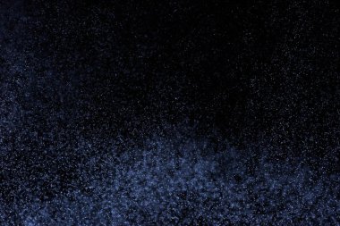 Siyah arka plan üzerine su sıçramalarına soyut mavi. Beyaz parçacıkların hareket dondurmak. Yağmur, kar doku yerleşimi..