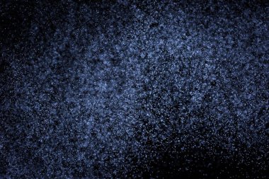 Siyah arka plan üzerine su sıçramalarına soyut mavi. Beyaz parçacıkların hareket dondurmak. Yağmur, kar doku yerleşimi..