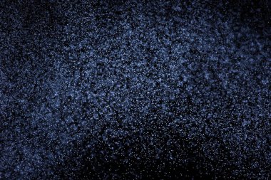 Siyah arka plan üzerine su sıçramalarına soyut mavi. Beyaz parçacıkların hareket dondurmak. Yağmur, kar doku yerleşimi..